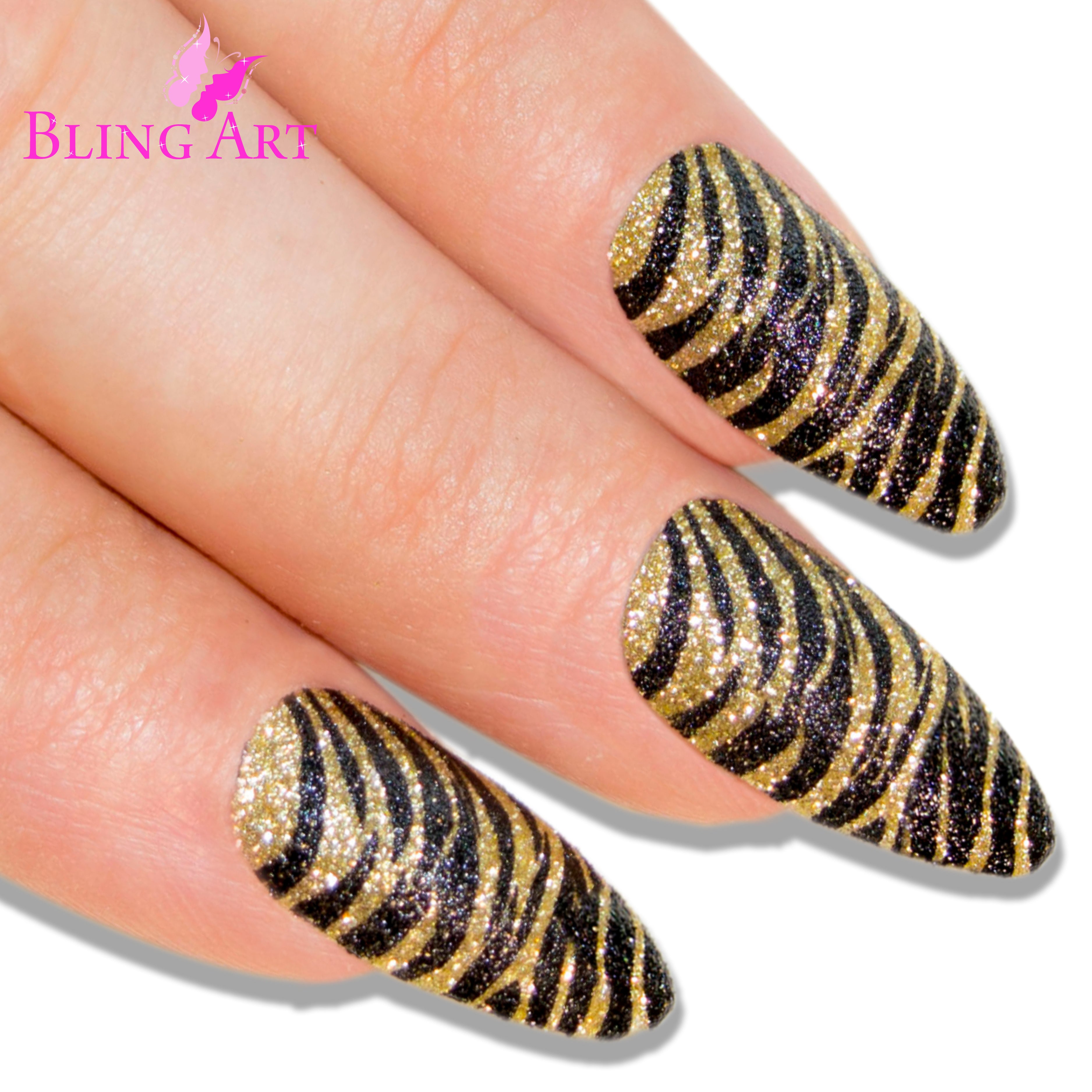 Gold Black almond stiletto Bling Art press-on nails — worn-hand close-up showing the two-tone champagne-gold and jet-black on long pointed almond stiletto tips. Almond = Stiletto (same shape).