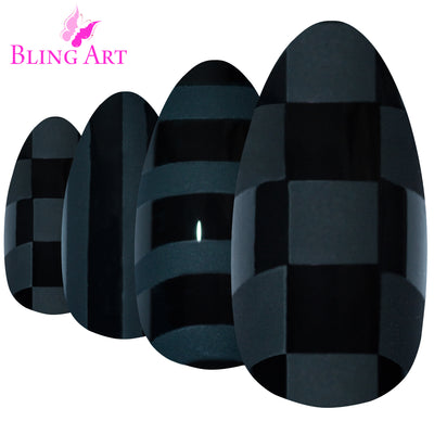 Matte Black almond stiletto Bling Art press-on nails — worn-hand close-up showing the bold velvet matte on long pointed almond stiletto tips. Almond = Stiletto (same shape).