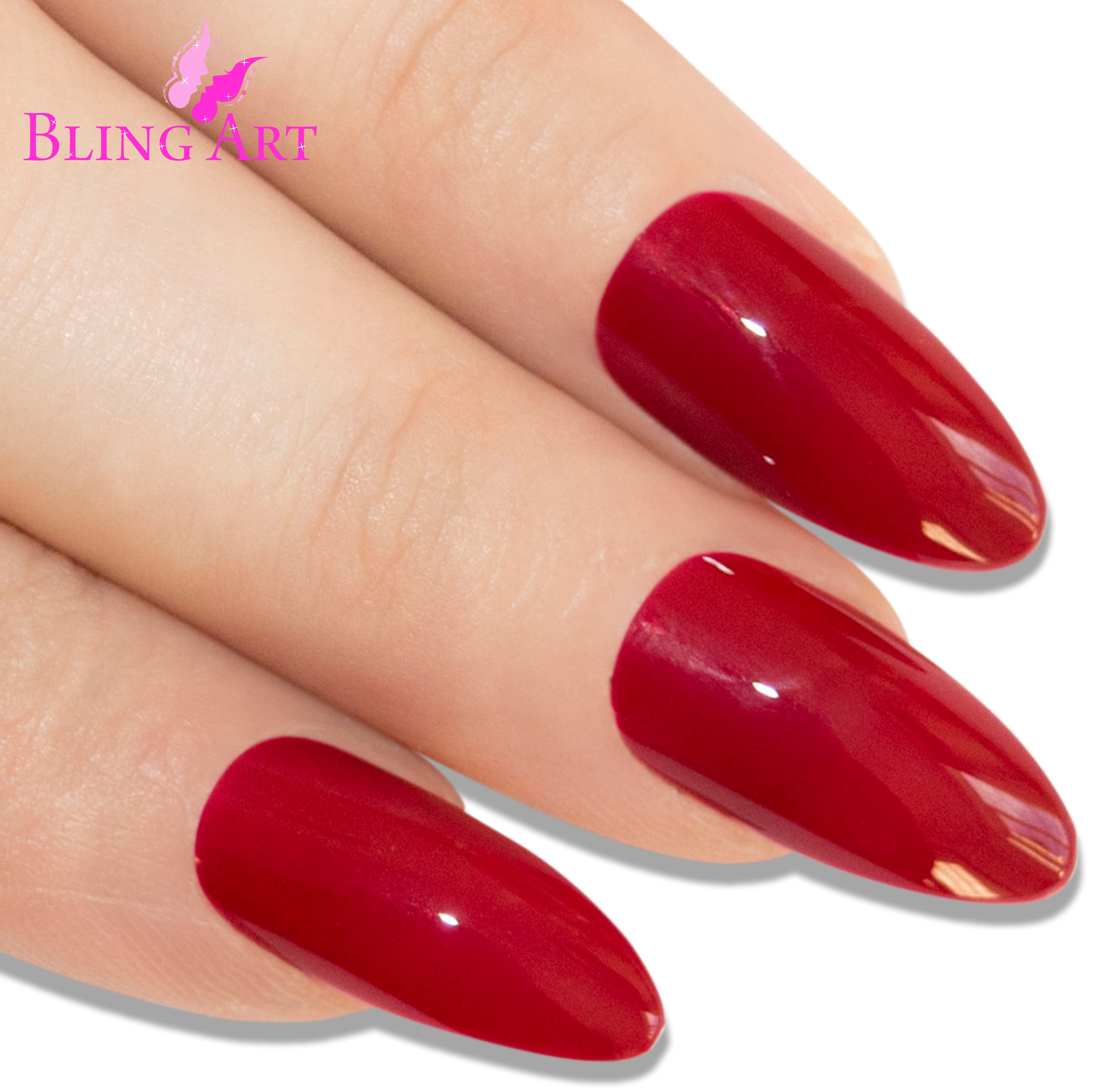 Red polished almond stiletto Bling Art press-on nails — worn-hand close-up showing the crimson high-shine on long pointed almond stiletto tips. Almond = Stiletto (same shape).