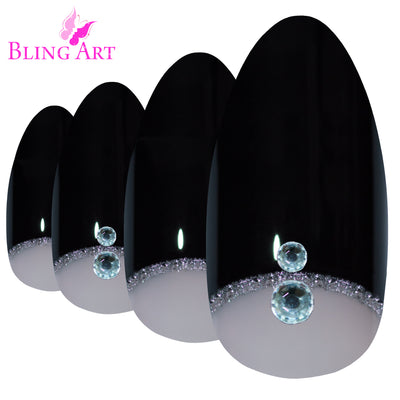 Black glitter almond stiletto Bling Art press-on nails — worn-hand close-up showing the crystal-cut black glitter on long pointed almond stiletto tips. Almond = Stiletto (same shape).