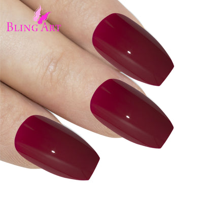 Red polished ballerina coffin Bling Art press-on nails — worn-hand close-up showing the crimson high-shine on long ballerina coffin tips. Ballerina = Coffin (same shape).