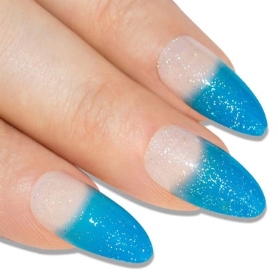 Vivid blue gel-glitter almond stiletto long press-on false nails by Bling Art — bold sparkle for festivals, parties, and summer events · embedded fine blue glitter with glossy gel coat · long almond stiletto tips · 24 nails per set with adhesive · designed in Yorkshire